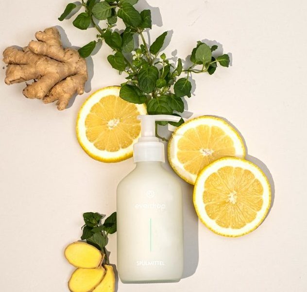 a white vase filled with lemons next to a plant